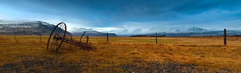 A rusty mower_wintry pasture and snow covered mountains on the south coast of Iceland