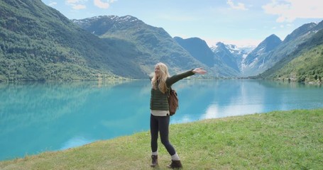 Beautiful woman filming dancing video using smartphone outdoors glacial lake Crazy Vlogger Girl Sharing selfie dancer video on social media travel vlog enjoying Norway vacation travel adventure - Powered by Adobe