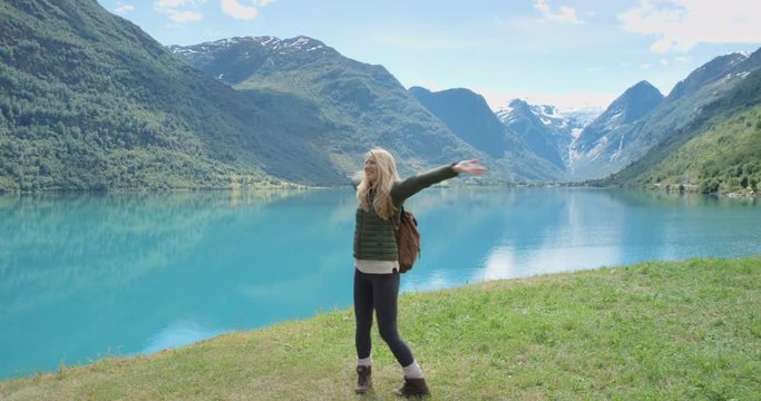 Beautiful woman filming dancing video using smartphone outdoors glacial lake Crazy Vlogger Girl Sharing selfie dancer video on social media travel vlog enjoying Norway vacation travel adventure