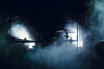 Drum set in smoke on a stage - obrazy, fototapety, plakaty