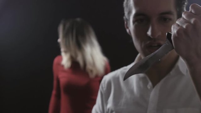 Domestic Violence. Evil husband with a knife wants to kill his wife