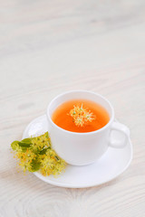 linden tea in a white cup on a light background, 