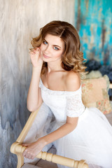 Fototapeta na wymiar Beautiful bride in a gorgeous dress in the loft room.