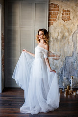 Obraz premium Beautiful bride in a gorgeous dress in the loft room.