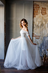 Fototapeta premium Beautiful bride in a gorgeous dress in the loft room.
