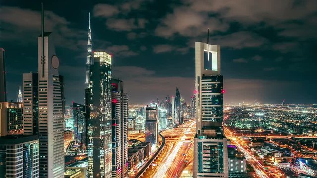 Downtown Dubai skyscrapers at night. Scenic aerial view of famous highway with fast moving traffic. 4K time lapse.