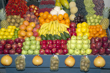 Wide angle photo of many colorful fruits on farmers market stand