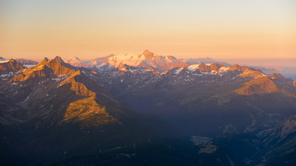 Warm light at sunrise on mountain peaks, ridges and valleys