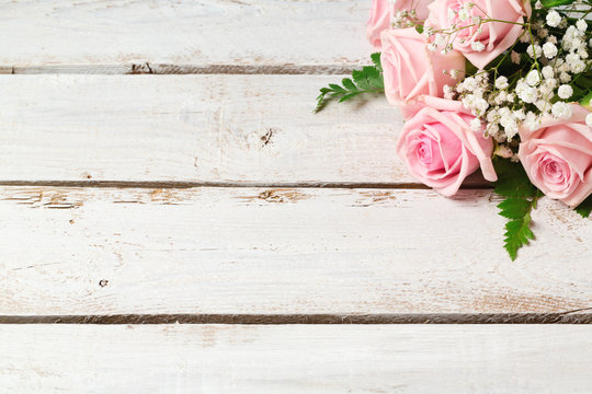 Background with rose flowers bouquet on wooden vintage table
