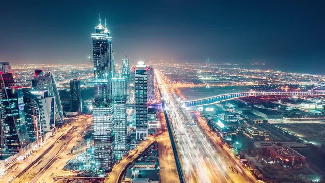 Fantastic nighttime skyline of a big modern city. Scenic aerial view of Dubai downtown skyscrapers and highways with light trails. 4K time lapse. Colouful travel background.