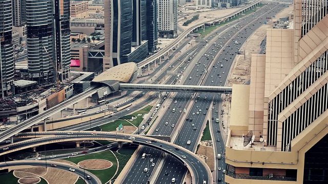 Spectacular daytime skyline of downtown Dubai, UAE. Scenic aerial view of famous highway intersection at sunset. Transportation and travel background

