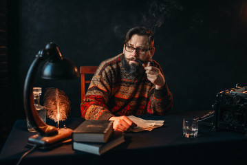 Bearded writer in glasses smoking a pipe