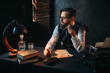 Bearded writer in glasses smoking a pipe - obrazy, fototapety, plakaty
