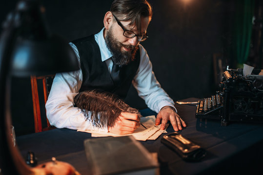 Bearded journalistr in glasses writes with feather
