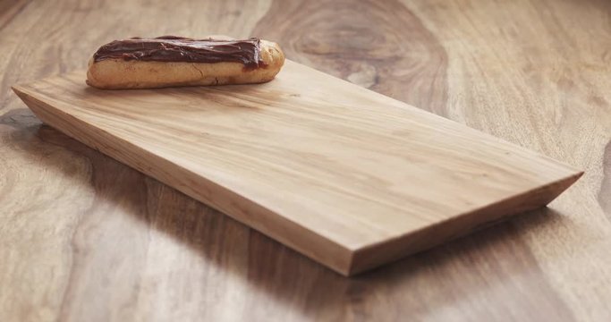 young female hand put eclairs with chocolate on wood board, 4k 60fps prores footage