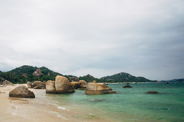 Obraz premium Beautiful landscape with view of ocean, perfect beach, big stones, trees, azure water. Background image. Concept travel