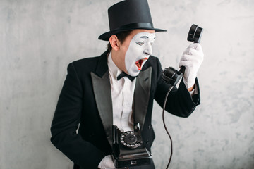 Naklejka premium Pantomime actor performing with retro telephone