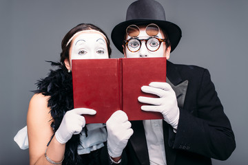 Two comedy performers posing with book - obrazy, fototapety, plakaty
