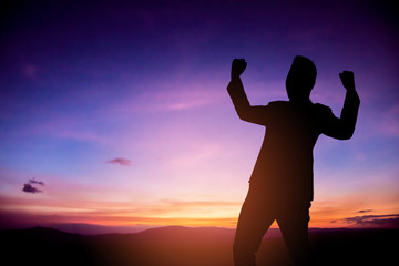 Businessman happy and do hands up on hill at sunrise period