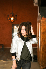Fototapeta premium Girl posing in a silver jacket. The Studio photos. r