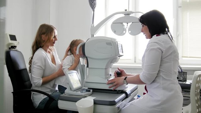 Mother and child - little girl in the ophthalmologist's room- optometrist in clinic checking little child's vision