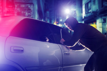 car thief in action at night. Car Security Theme. - obrazy, fototapety, plakaty