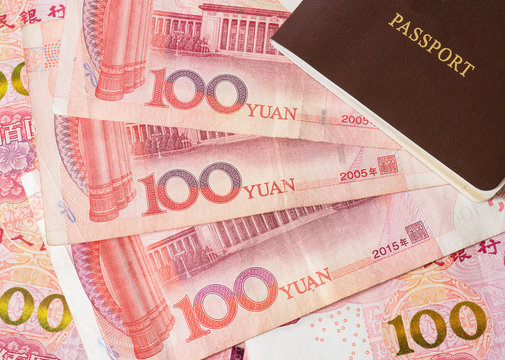 Close up Chinese Yuan bank notes currency and passport.