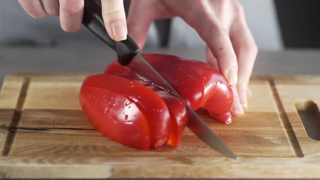 Chef cuts peppers for making vegetable dish, fresh vegetable salad, healthy cooking at home, fresh vegetables in the kitchen