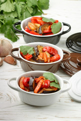 Baked vegetables in portion pots. Eggplant, bell pepper, carrot, onion, garlic, cilantro. Vegetarian dish. Selective focus