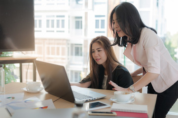 Young Asian women workers working together in office