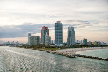 Obraz premium Miami skyscrapers with blue cloudy sky, boat sail, Aerial view