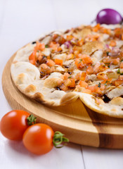 Focaccia with tomato and onions on a wooden board on a white background