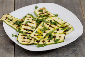 Grilled zucchini on a white plate.