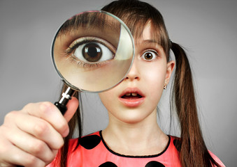 surprised child girl, searching  with magnifying glass