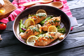 Pan with delicious chicken breasts on wooden table