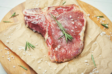 Seasoned steak with rosemary on parchment