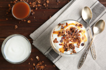 Glass of delicious dessert with ingredients on wooden background