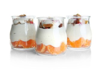 Glass jars of delicious dessert on white background