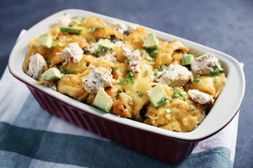 Roasted chicken with cheese in casserole dish on kitchen table