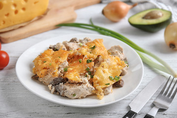 Plate with roasted chicken and cheese on kitchen table