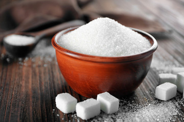 White sand and lump sugar with bowl on wooden background