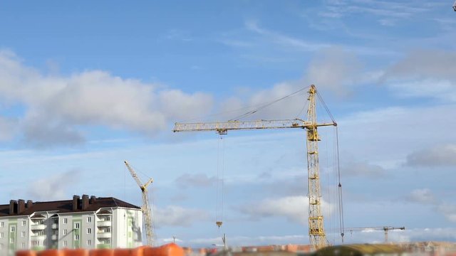 Construction cranes work at construction site of dwelling complex. Timelapse