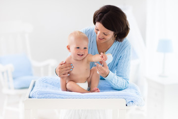 Mother changing diaper to baby boy