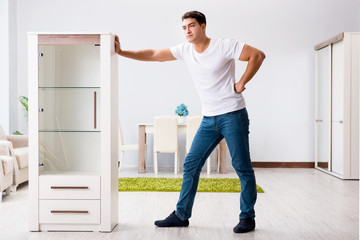 Fototapeta na wymiar Young man moving furniture at home