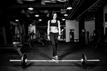 Obraz na płótnie Canvas Muscular young fitness woman preparing for heavy deadlift exercise in gym