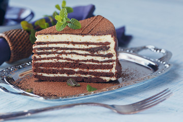Slice of delicious chocolate cake on silver plate