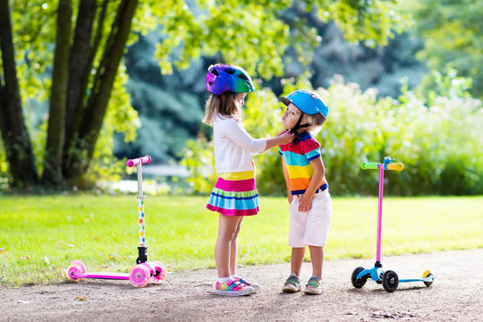 Kids riding scooter in summer park.