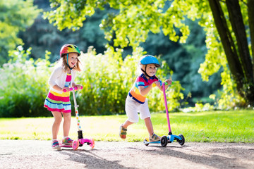 Kids riding scooter in summer park. © famveldman