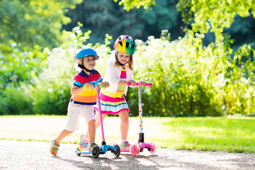 Kids riding scooter in summer park. © famveldman