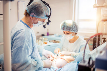 Surgeons team working with Monitoring of patient in surgical operating room. breast augmentation